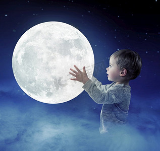 一个可爱的小男孩拿着月亮的艺术肖像
