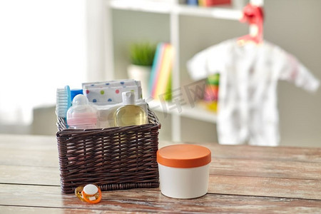 婴幼儿护理产品概念-家中木桌上柳条筐内的婴幼儿用品。家里木桌上篮子里的婴儿用品