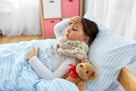 健康，儿童和人的概念-生病的女孩躺在家里的床上。生病的女孩躺在家里的床上