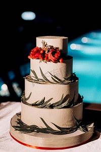 金色婚礼装饰摄影照片_婚礼装饰与蛋糕在一个木凳上反对瀑布背景