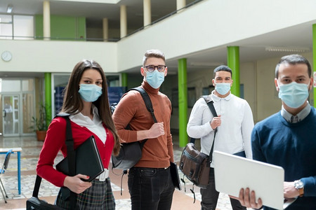 多民族学生群体在大学走廊戴防护口罩新常态冠状病毒时代教育理念