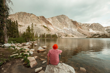 一个人正在平静的湖边悠闲地休息。放松的假期