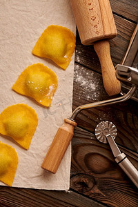 原汁原味的自制意大利饺子配上菠菜和意大利乳清乳酪，配以木质质朴的背景。意大利饺子的制作过程。
