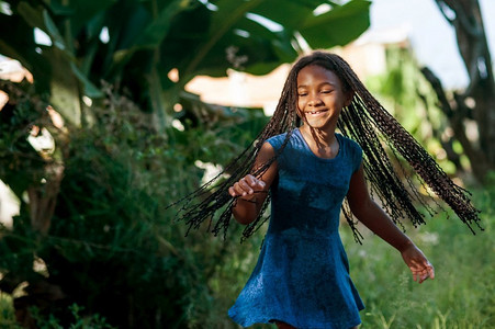 年轻的非洲女孩在大自然中嬉戏跳舞