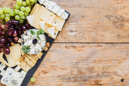 拼盘奶酪配葡萄，黑色石板板桌。高分辨率照片。拼盘奶酪配葡萄，黑色石板板桌。高质量照片