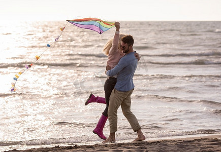 秋天的一对小情侣在海滩上玩风筝