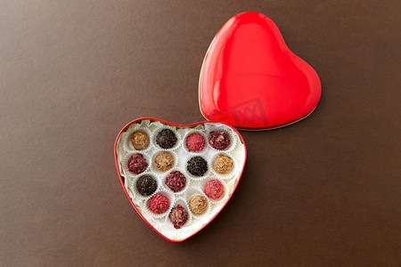 糖果，糖果和食物概念—糖果在红色心脏形状的巧克力盒在棕色背景糖果在红心形状巧克力盒