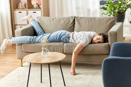 人，无聊和抑郁的概念—无聊或懒惰的年轻女子躺在沙发上在家里。无聊或懒惰的年轻妇女躺在沙发上在家