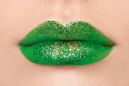 圣帕特里克节的概念照片。’近距离观看妇女嘴唇与绿色唇膏。假日化妆