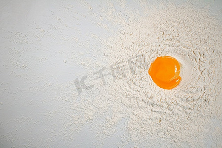 做自制蛋糕。生鸡蛋放在一堆面粉里。在白色背景上..做自制蛋糕。生鸡蛋放在一堆面粉里。