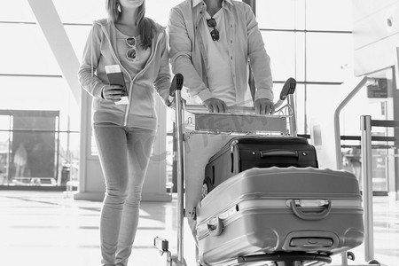 肖像男子推行李车办理登机手续与她的女儿在机场
