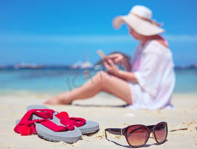在热带海滩上使用智能手机的放松女人
