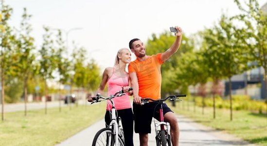 健身的情侣摄影照片_健身、自行车、智能手机、自拍