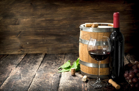 一桶红葡萄酒和一个开瓶器。在一个木制的背景下。一桶红葡萄酒和一个开瓶器。