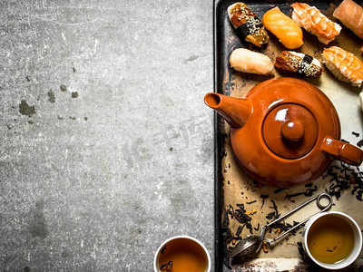 寿司海鲜和草药茶在一个旧托盘。寿司海鲜和凉茶