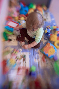 教育摄影照片_可爱的小婴儿玩玩具在移动床上使第一步和学习站立和行走