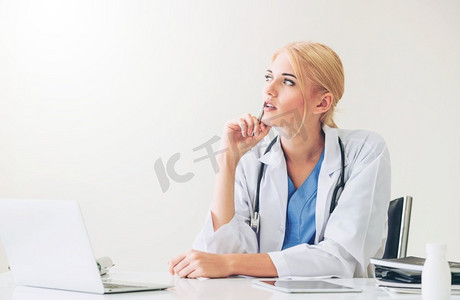 医院或保健机构的女医生在办公室桌子上做医疗报告。医院里的医生在写医疗报告。