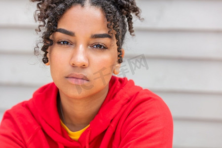 十几岁的少女年轻的非裔美国混血女子外面穿着红色连帽衫，显得若有所思