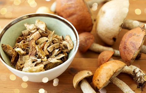 烹饪、食品和烹饪概念-木质背景碗中的干蘑菇。木质背景碗装干蘑菇
