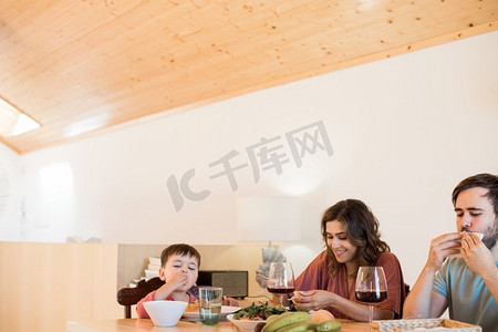 母亲与小孩子摄影照片_年轻的家庭与一个小孩子坐在一起吃午餐