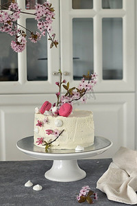 用鲜花和一杯酒装饰的春天纪念日蛋糕