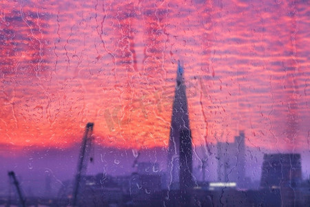 高空擦玻璃摄影照片_伦敦市的美丽风景概念视图通过玻璃窗与雨滴运行下来的玻璃
