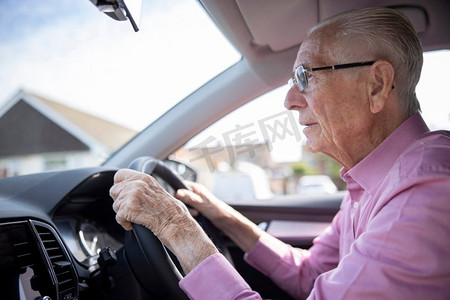 老年人焦虑摄影照片_忧心忡忡的高级男司机透过汽车挡风玻璃看