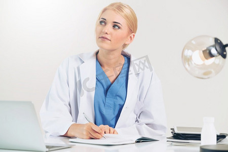健康报告摄影照片_医院或保健机构的女医生在办公室桌子上做医疗报告。医院里的医生在写医疗报告。