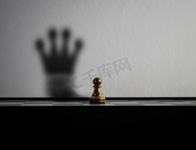 赢得皇冠摄影照片_Chessman变成了皇冠的影子。主意概念