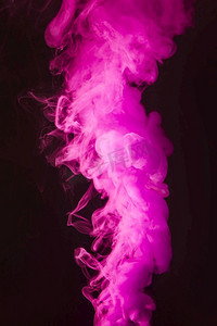 抽象烟雾摄影照片_抽象密集蓬松的粉红色烟雾在黑色背景