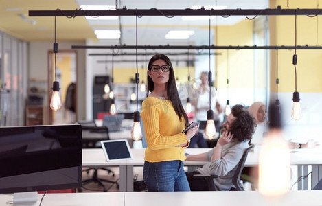 女商人肖像在开放空间启动共同工作开放空间办公室作为影响者使用智能电话，平板电脑