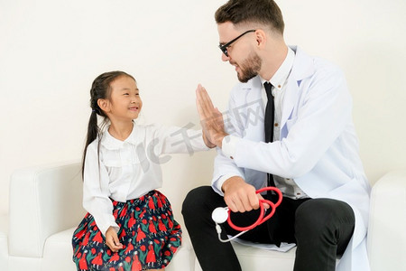小孩子到医院的办公室看病。这孩子很开心，也不怕医生。医疗和儿童保健概念。