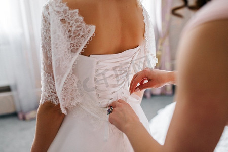 把新娘穿上一件有紧身胸衣和花边的婚纱