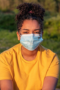 混合种族非洲裔美国人青少年少女年轻女子戴面罩外面在冠状病毒COVID—19大流行