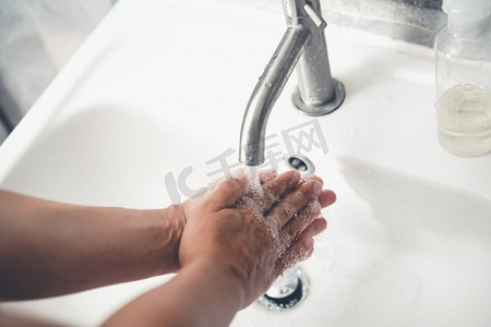 欧式洗手池摄影照片_洗手以预防新型冠状病毒病2019或COVID—19。人们在洗手池洗手以清除病毒感染。
