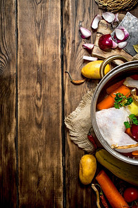 用蔬菜和香料煮鸡汤的材料。在一张木桌上。用蔬菜和香料煮鸡汤的材料。