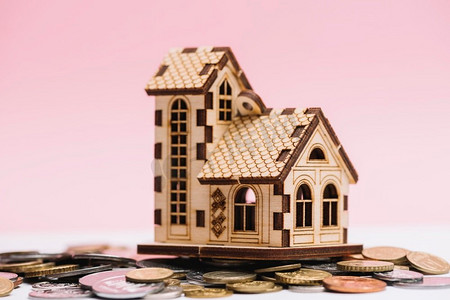 房子模型硬币前面粉红色背景。高分辨率照片。房子模型硬币前面粉红色背景。高品质的照片