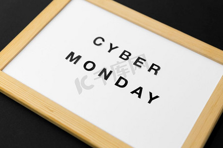 电商黑金字摄影照片_购物，销售和出口概念—白色磁性板与网络星期一字在黑色背景。磁性板与Cyber Monday单词