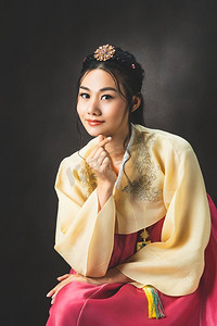 穿着传统韩国服装（韩服）的韩国妇女在黑色背景在工作室。美丽的韩国文化。