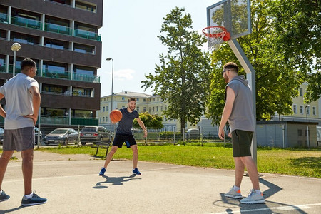 运动、休闲游戏和男性友谊的概念--一群男人或朋友在街头打篮球。一群在街头打篮球的男性朋友