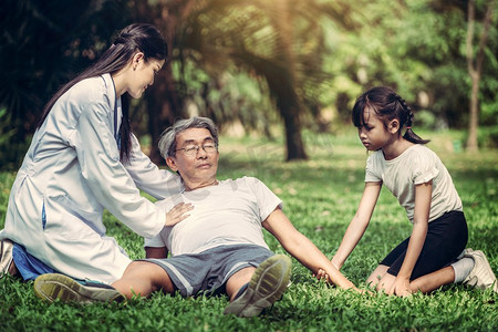 一位老人在公园里有胸痛或心脏病发作。老年人老年人保健概念医生帮助晕倒在地上的老年人。