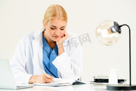 女医生在医院或保健研究所工作的医疗报告在办公桌。医生在医院做医疗报告。