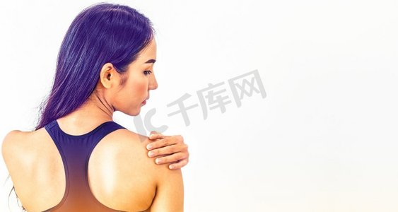 运动妇女触摸肩膀在健身房。健康的生活方式理念。