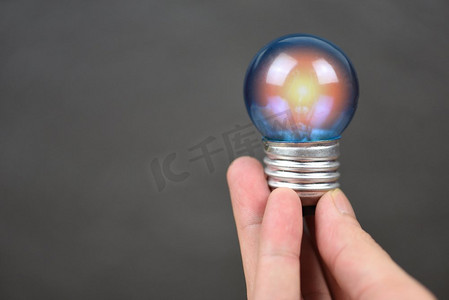 手持灯泡来自黑底灯泡/节能理念、节电与世界理念