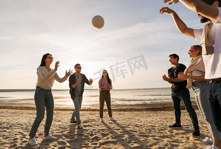 排球，休闲游戏和人的概念—快乐的朋友在沙滩上玩球在夏天。夏天在沙滩上打排球的朋友