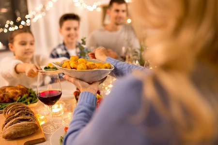庆祝，节假日和人的概念-幸福的家庭在家里吃晚餐。幸福的一家人在家里吃晚餐