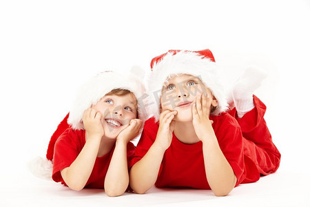 窃窃私语摄影照片_两个做梦的小男孩躺在圣诞老人的帽子里，