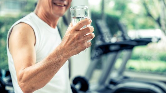 老年人运动后到健身中心喝矿泉水。老年人健康生活方式老年人在健身中心喝矿泉水。