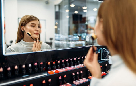 女顾客在化妆品店照镜子。在美容店、化妆沙龙选择指甲油