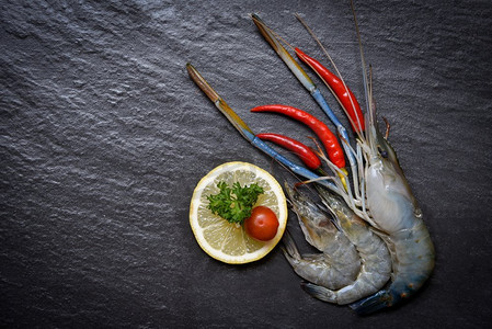 海鲜虾、贝类/鲜虾、海洋美食、生虾配辣椒、西红柿、柠檬和青芹，底色为深色